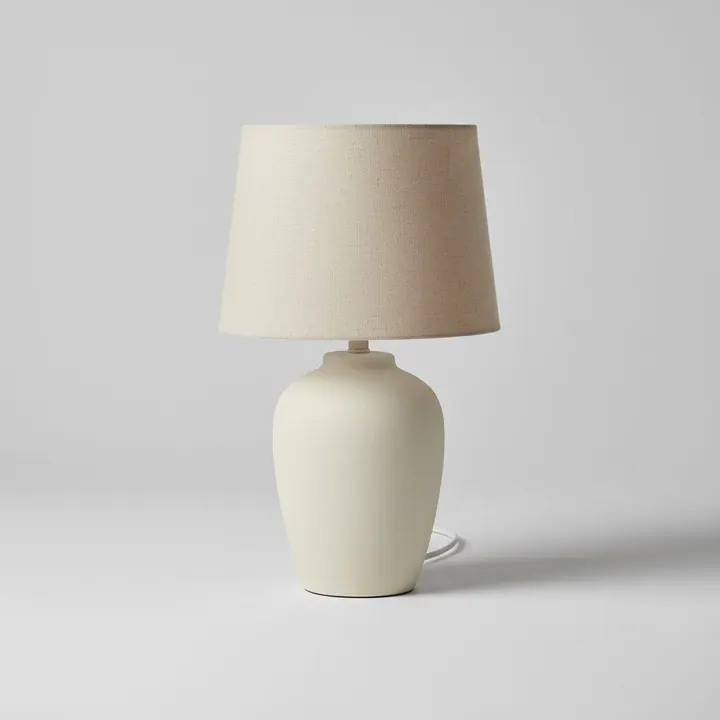 Source packshot of a ceramic table lamp with a linen shade